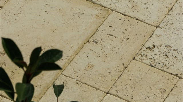 Bézs színű, travertin hatású térkővel burkolt terasz cserepes növénnyel